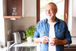 older man holding coffee cup.