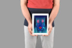 man holding tablet with prostate organs as image on screen.