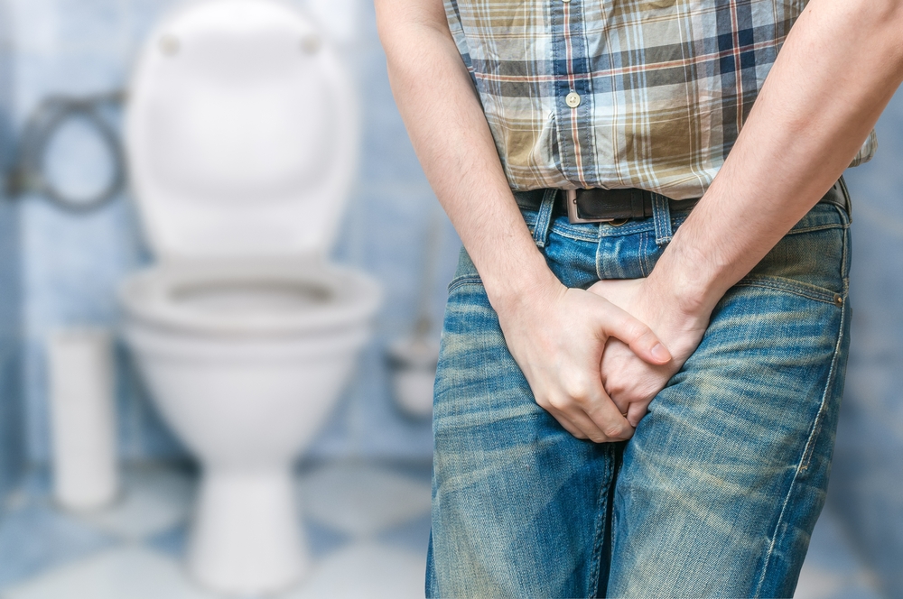 man holding bladder because he needs to pee urgently.